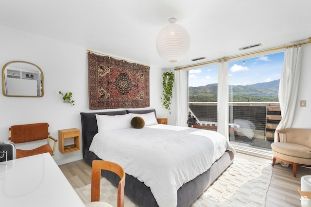 777 E S Temple S Unit 15E, Salt Lake City, UT 84102 - bedroom with light wood finished floors, access to outside, a mountain view, and expansive windows