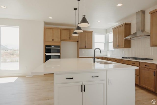 1026 W Chokecherry Dr Unit 135, Mapleton, UT 84664 - kitchen featuring wall chimney range hood, stainless steel gas stovetop, light wood-style flooring, tasteful backsplash, and light countertops
