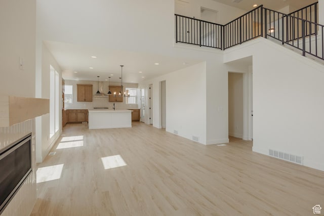 1026 W Chokecherry Dr Unit 135, Mapleton, UT 84664 - unfurnished living room featuring a towering ceiling, light wood-style floors, stairway, and recessed lighting