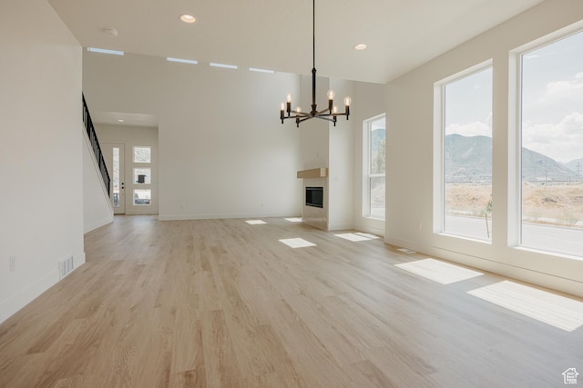 1026 W Chokecherry Dr Unit 135, Mapleton, UT 84664 - unfurnished dining area featuring a chandelier, light wood-style flooring, a glass covered fireplace, recessed lighting, and a mountain view