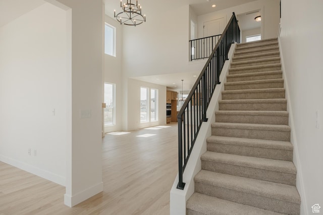 1026 W Chokecherry Dr Unit 135, Mapleton, UT 84664 - stairway with plenty of natural light, a chandelier, wood finished floors, and a high ceiling