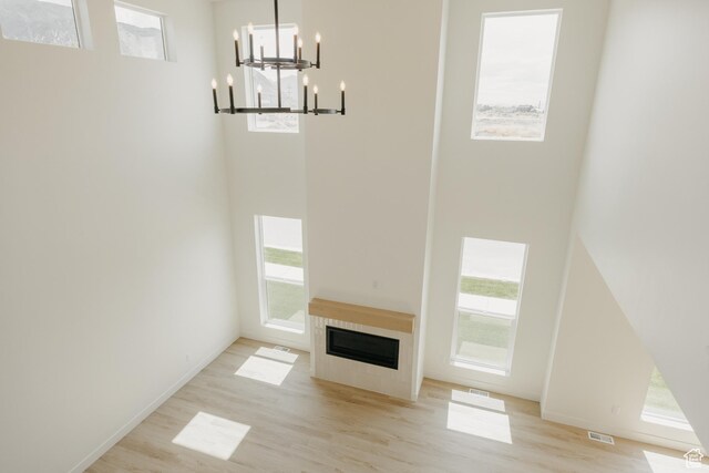 1026 W Chokecherry Dr Unit 135, Mapleton, UT 84664 - unfurnished living room with a chandelier, wood finished floors, healthy amount of natural light, and a high ceiling