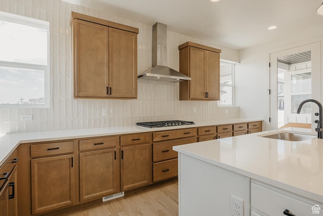 1026 W Chokecherry Dr Unit 135, Mapleton, UT 84664 - kitchen with wall chimney range hood, stainless steel gas cooktop, brown cabinets, and recessed lighting