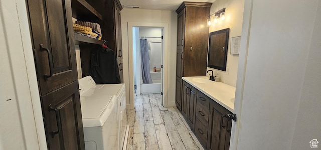 1275 S Lawrence Rd, Huntington, UT 84528 - full bathroom featuring washer and dryer, double vanity, wood finished floors, and shower / tub combo