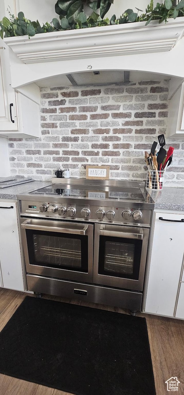 1275 S Lawrence Rd, Huntington, UT 84528 - kitchen with double oven range, white cabinetry, light countertops, exhaust hood, and wood finished floors