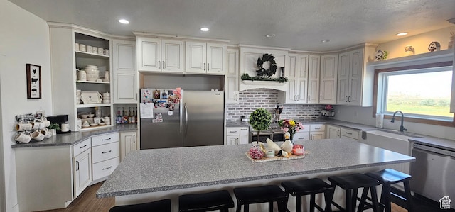 1275 S Lawrence Rd, Huntington, UT 84528 - kitchen featuring stainless steel appliances, open shelves, a breakfast bar area, a center island, and dark wood-style flooring