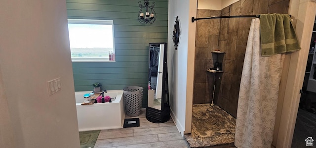1275 S Lawrence Rd, Huntington, UT 84528 - bathroom with a stall shower, a garden tub, wooden walls, wood finished floors, and a chandelier