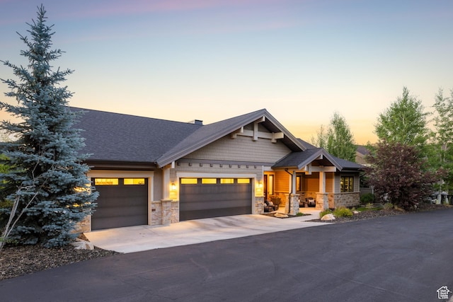 4014 W Hidden Cv Unit 11, Park City, UT 84098 - craftsman-style house featuring stone siding, driveway, an attached garage, a porch, and roof with shingles