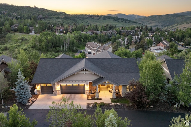 4014 W Hidden Cv Unit 11, Park City, UT 84098 - craftsman-style home with stone siding, a garage, driveway, a mountain view, and a shingled roof