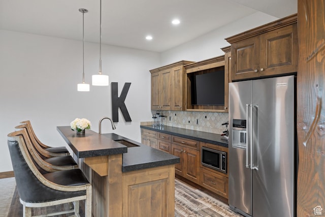 4014 W Hidden Cv Unit 11, Park City, UT 84098 - kitchen with stainless steel appliances, dark countertops, decorative backsplash, recessed lighting, and a kitchen island with sink