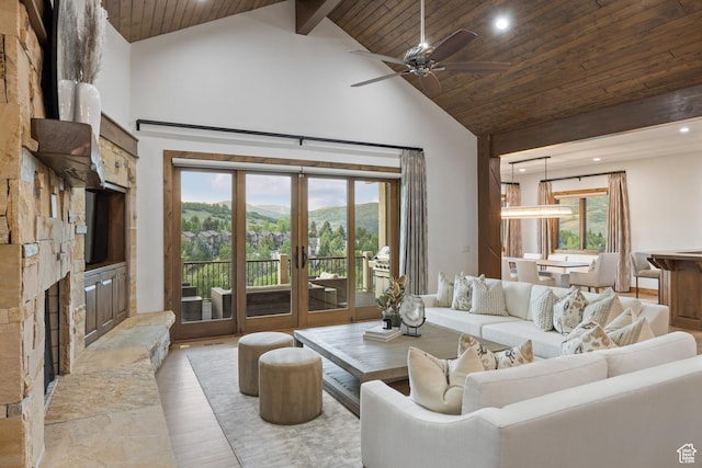 4014 W Hidden Cv Unit 11, Park City, UT 84098 - living area with high vaulted ceiling, wood ceiling, a mountain view, a stone fireplace, and french doors
