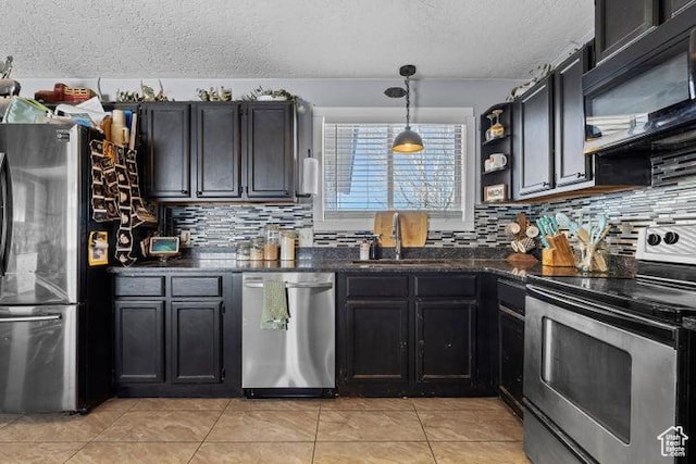 246 S 475 E, Enterprise, UT 84725 - kitchen featuring appliances with stainless steel finishes, a textured ceiling, dark countertops, tasteful backsplash, and light tile patterned flooring