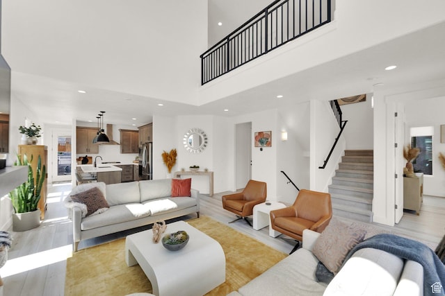 6927 W Higbrow Way S, Jordan, UT 84009 - living area featuring stairs, recessed lighting, a towering ceiling, and light wood-type flooring
