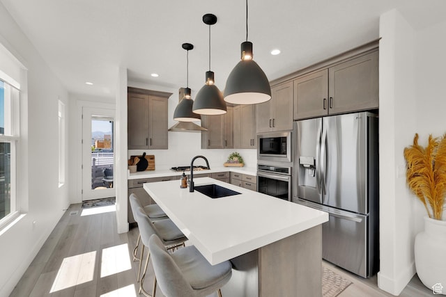 6927 W Higbrow Way S, Jordan, UT 84009 - kitchen with appliances with stainless steel finishes, light countertops, an island with sink, recessed lighting, and decorative backsplash
