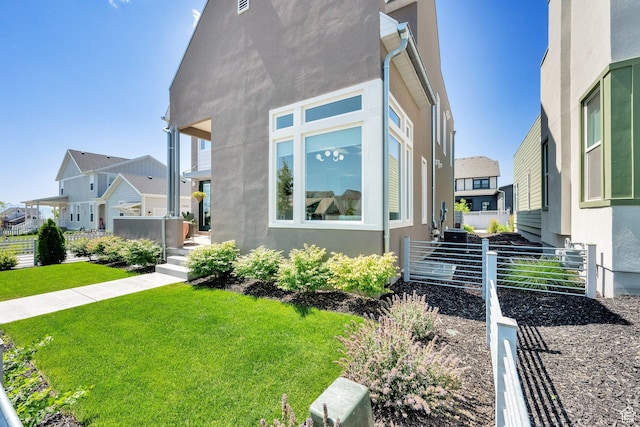 6927 W Higbrow Way S, Jordan, UT 84009 - view of property exterior featuring stucco siding, a yard, and a residential view