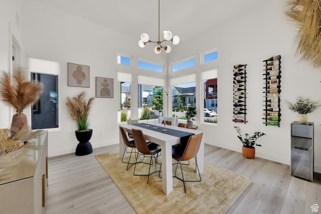 6927 W Higbrow Way S, Jordan, UT 84009 - dining room featuring a chandelier, light wood finished floors, and a towering ceiling