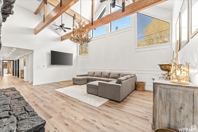 1960 N Lake Dr, Scofield, UT 84526 - living area with high vaulted ceiling, ceiling fan, a decorative wall, beamed ceiling, and light wood-style flooring