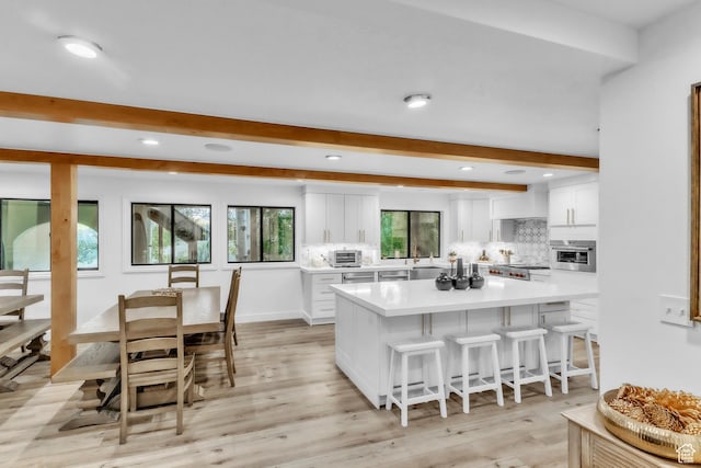 1960 N Lake Dr, Scofield, UT 84526 - kitchen featuring beam ceiling, a breakfast bar area, white cabinetry, recessed lighting, and a kitchen island