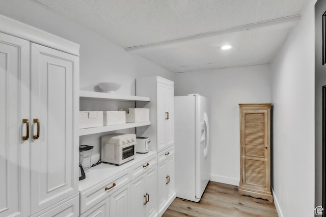 1960 N Lake Dr, Scofield, UT 84526 - kitchen with white refrigerator with ice dispenser, open shelves, light wood-style flooring, white cabinetry, and light countertops