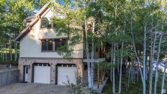 1960 N Lake Dr, Scofield, UT 84526 - view of property exterior featuring stucco siding, brick siding, a garage, and gravel driveway