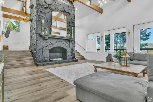 1960 N Lake Dr, Scofield, UT 84526 - living room featuring beamed ceiling, wood finished floors, a stone fireplace, high vaulted ceiling, and stairs