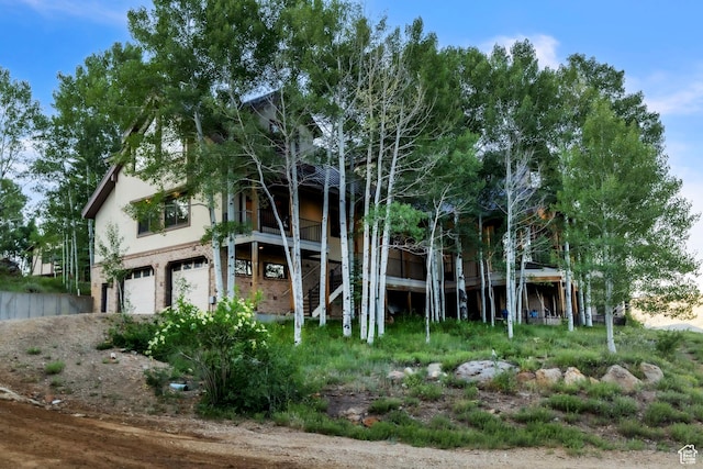 1960 N Lake Dr, Scofield, UT 84526 - rear view of property featuring stairway, an attached garage, and stucco siding
