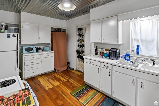 340 N Main St, Monroe, UT 84754 - kitchen with white appliances, light countertops, hardwood / wood-style flooring, and white cabinetry