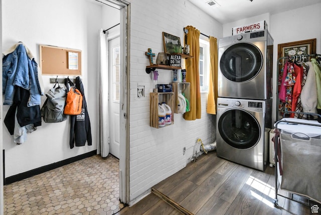 340 N Main St, Monroe, UT 84754 - laundry area featuring stacked washing machine and dryer, wood finished floors, and brick wall