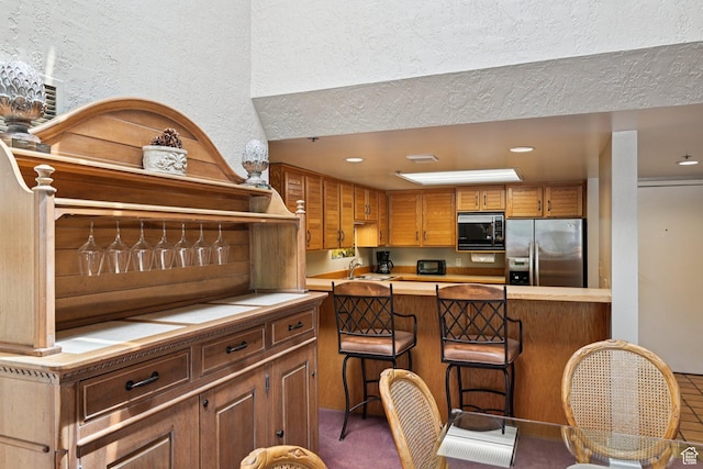 1485 Empire Ave Unit 513, Park City, UT 84060 - kitchen with stainless steel refrigerator with ice dispenser, light countertops, a kitchen bar, recessed lighting, and a textured ceiling
