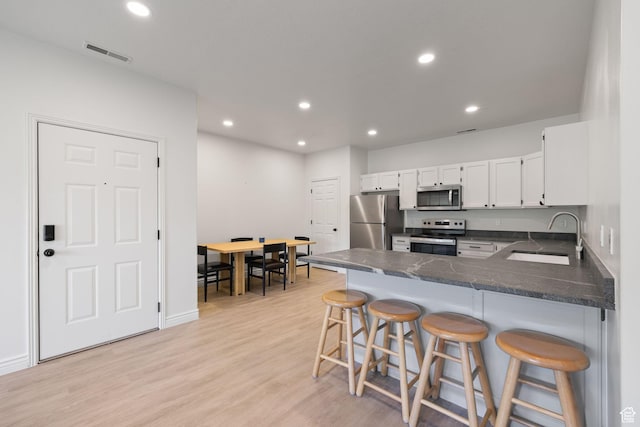 392 N Seven Peaks Blvd Unit 322, Provo, UT 84606 - kitchen featuring stainless steel appliances, white cabinets, a peninsula, recessed lighting, and light wood-style flooring