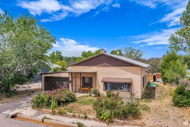 373 N 400 W, Cedar City, UT 84721 - view of front of property featuring a garage, a chimney, stucco siding, and driveway