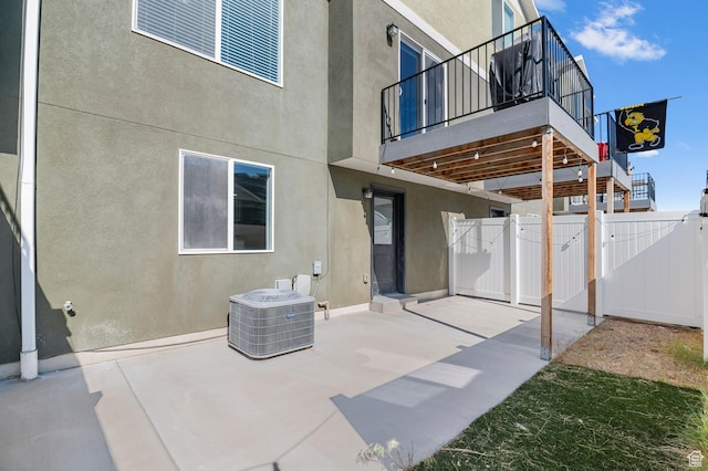 14907 S Messi St, Herriman, UT 84096 - rear view of house featuring stucco siding, a patio, a gate, and a balcony