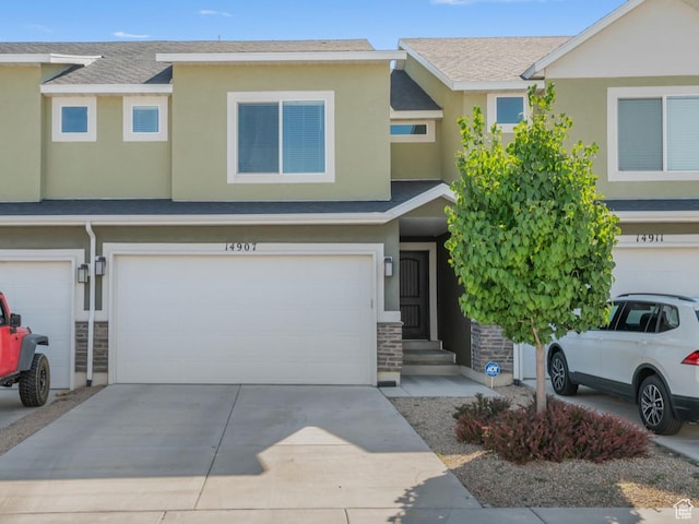 14907 S Messi St, Herriman, UT 84096 - view of property featuring a garage, stucco siding, driveway, and stone siding