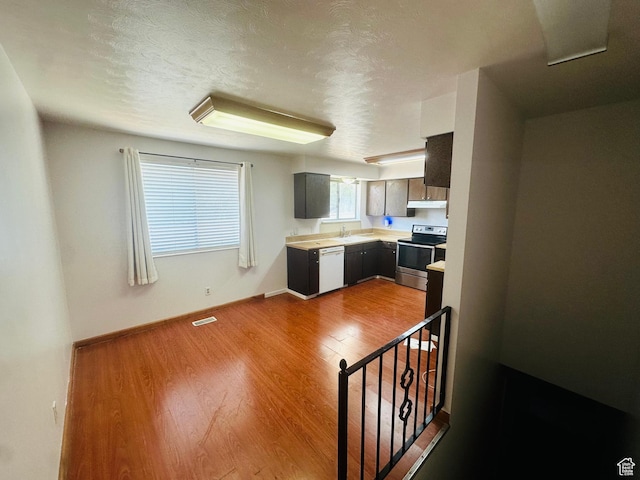 5465 W 5400 S, Kearns, UT 84118 - kitchen with stainless steel range with electric cooktop, white dishwasher, under cabinet range hood, light countertops, and dark wood finished floors
