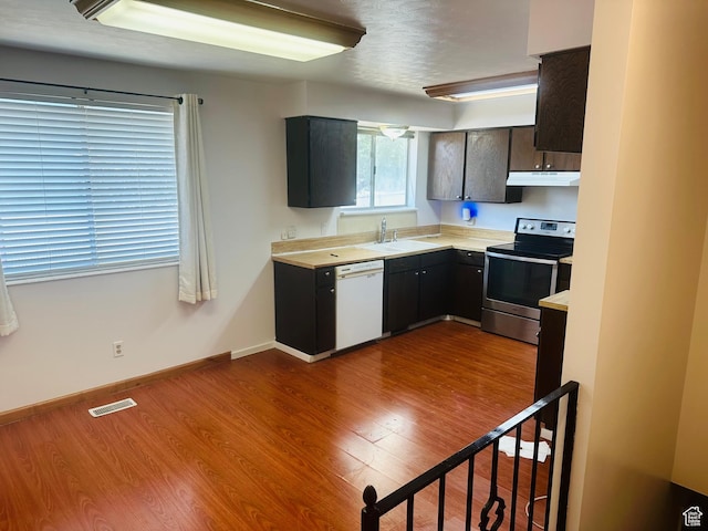 5465 W 5400 S, Kearns, UT 84118 - kitchen with electric range, dishwasher, under cabinet range hood, light countertops, and dark wood-style flooring