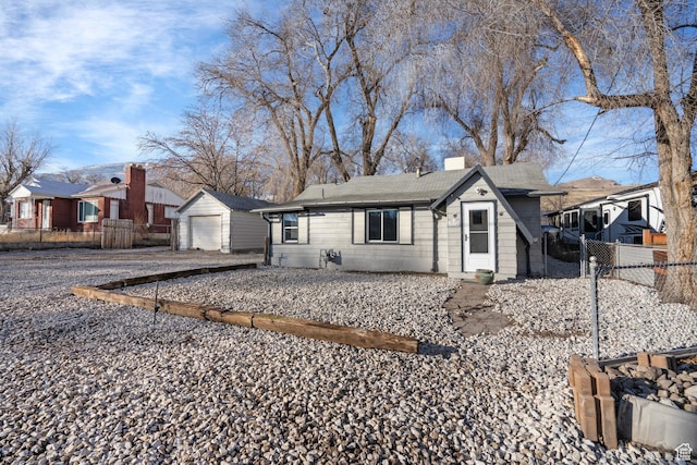 3174 S 9100 W, Magna, UT 84044 - view of front of home with a detached garage, roof with shingles, a chimney, an outdoor structure, and driveway