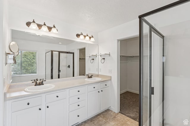 13316 S Moseley Way, Herriman, UT 84096 - bathroom featuring a stall shower, a walk in closet, double vanity, and a textured ceiling
