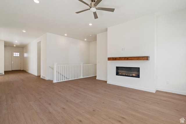 1502 W 1010 N Unit 11, Pleasant Grove, UT 84062 - unfurnished living room featuring light wood-type flooring, a ceiling fan, recessed lighting, and a glass covered fireplace