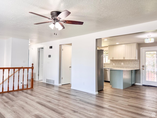 2072 W 5075 S, Roy, UT 84067 - kitchen with light wood-style flooring, stainless steel appliances, light countertops, a textured ceiling, and a ceiling fan