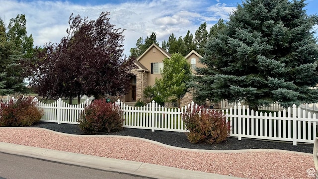 23 S 2200 W, Roosevelt, UT 84066 - view of property hidden behind natural elements featuring stone siding, a fenced front yard, and stucco siding