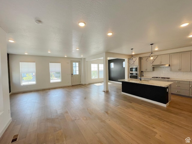11766 S Watercourse Rd, South Jordan, UT 84009 - kitchen featuring gray cabinets, built in microwave, open floor plan, gas stovetop, and an island with sink