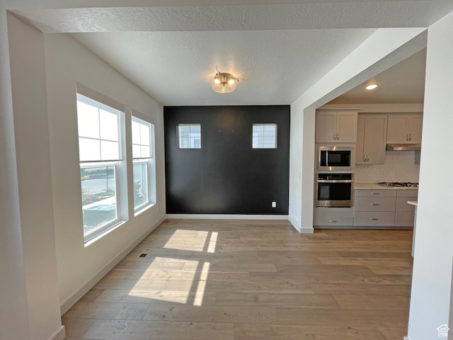 11766 S Watercourse Rd, South Jordan, UT 84009 - unfurnished dining area featuring healthy amount of natural light, light wood-style floors, recessed lighting, and a textured ceiling
