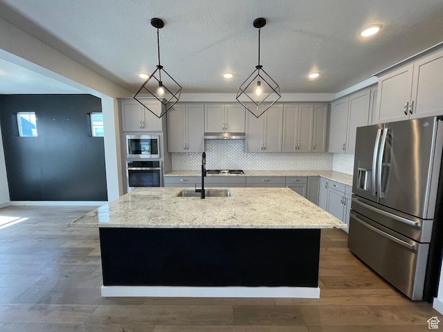 11766 S Watercourse Rd, South Jordan, UT 84009 - kitchen with appliances with stainless steel finishes, gray cabinetry, under cabinet range hood, backsplash, and recessed lighting