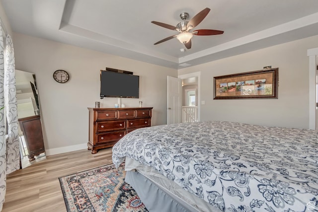 1934 E Sunnyvale Dr, Eagle Mountain, UT 84005 - bedroom featuring light wood finished floors, a tray ceiling, and ceiling fan