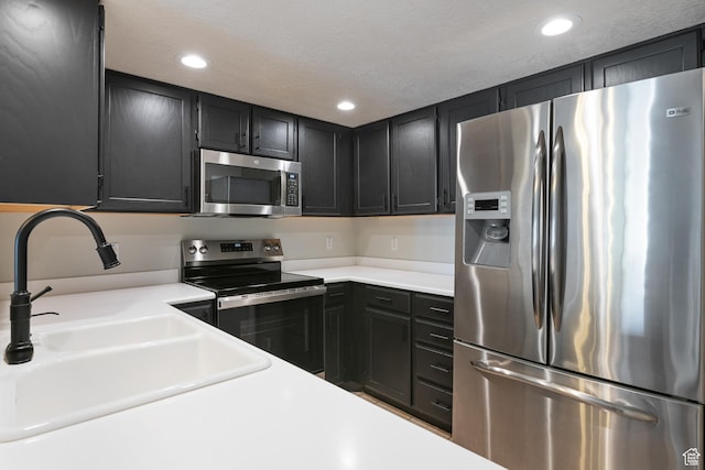 3760 S Carlisle Park Pl W Unit 3, Salt Lake City, UT 84119 - kitchen featuring appliances with stainless steel finishes, light countertops, recessed lighting, and dark cabinetry