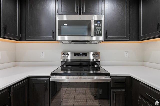 3760 S Carlisle Park Pl W Unit 3, Salt Lake City, UT 84119 - kitchen featuring stainless steel appliances, dark cabinetry, tile patterned floors, and light countertops
