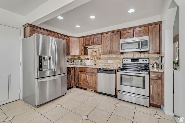 3822 S Chatterleigh Rd W, West Valley City, UT 84128 - kitchen featuring appliances with stainless steel finishes, backsplash, light stone countertops, and recessed lighting