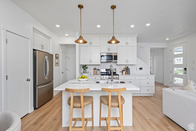 6031 W Highlandbrook Dr, West Jordan, UT 84081 - kitchen featuring stainless steel appliances, light countertops, light wood-type flooring, white cabinets, and recessed lighting