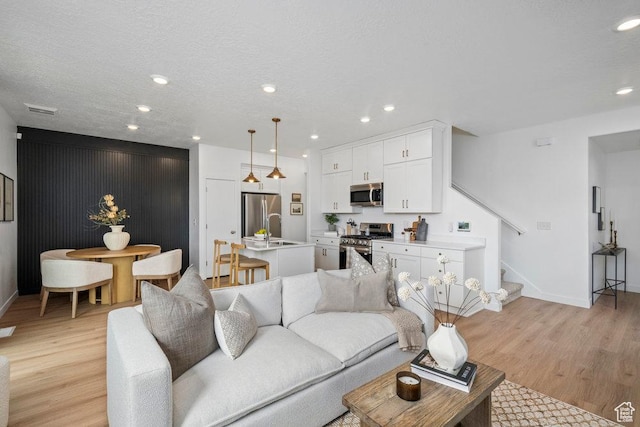 6031 W Highlandbrook Dr, West Jordan, UT 84081 - living area with light wood-style flooring, stairs, and recessed lighting