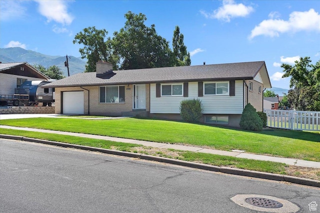 1414 E 275 N, Layton, UT 84040 - view of front of property featuring an attached garage, a mountain view, concrete driveway, a chimney, and brick siding